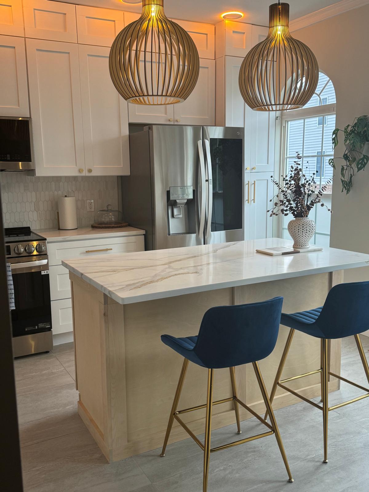 Kitchen remodel with quartz island, white shaker cabinets, and designer pendant lights