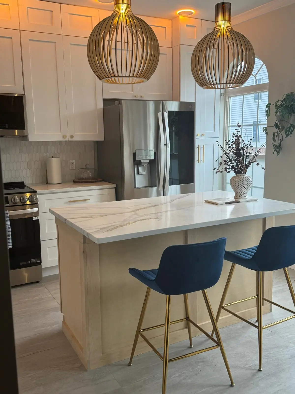 Kitchen remodel with quartz island, white shaker cabinets, and designer pendant lights