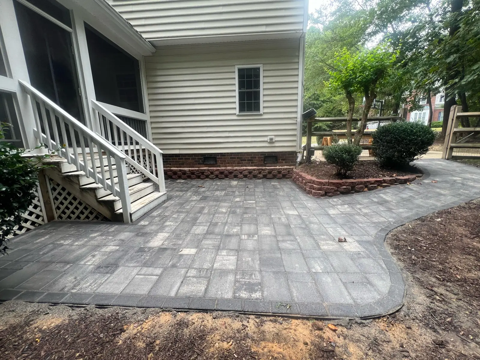 Outdoor patio installation with paver stones and landscaping