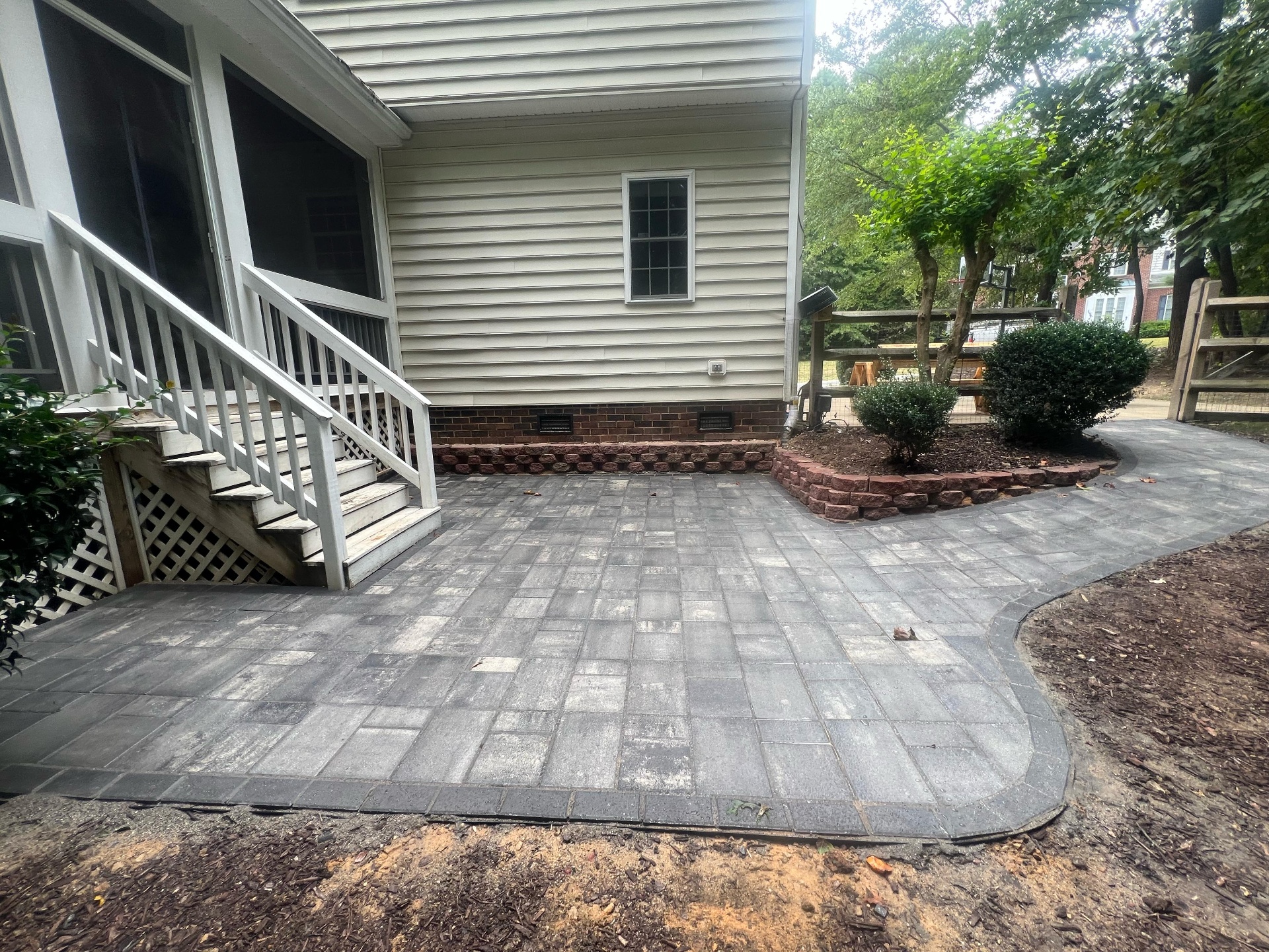 Outdoor patio installation with paver stones and landscaping